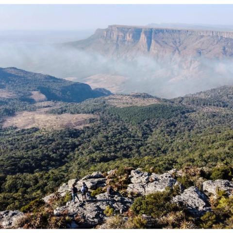 Fog hanging in a u shaped valley with uplifted cliffs in the distance