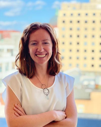 Amber in front of a blue sky with buildings in the background